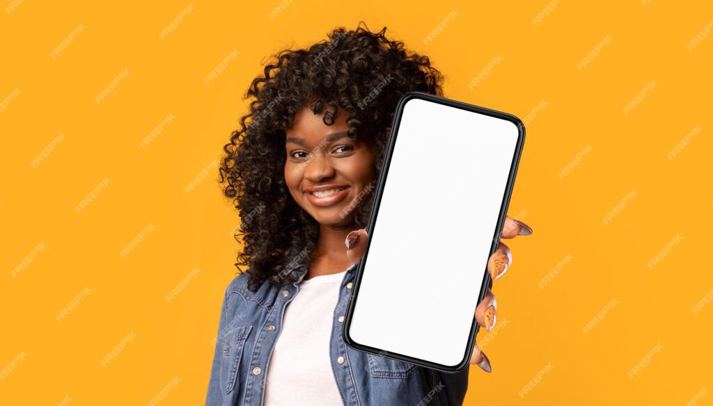 زن سیاه پوست شادی که تلفن همراه را روی ماکت زرد نشان می دهد- دانلود رایگان -موکاپ